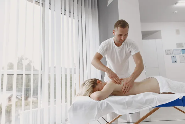 A massage therapist provides a relaxing back massage in a modern clinic setting. Hiring Massage Therapists Across State Lines
